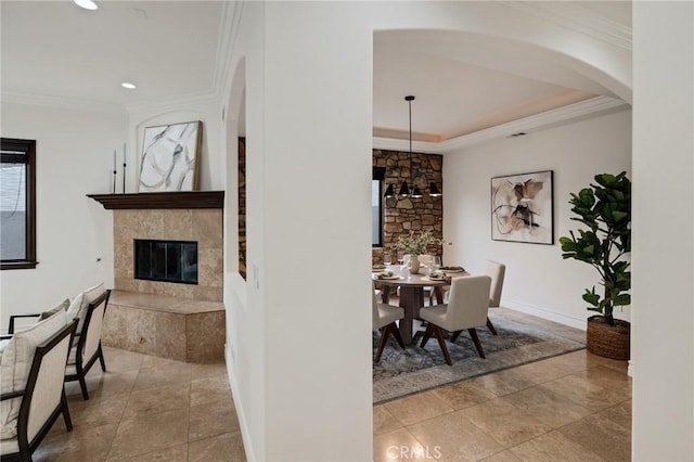 dining space featuring a tile fireplace and ornamental molding