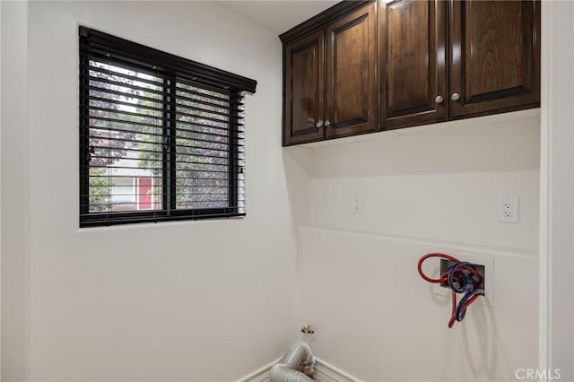 clothes washing area with cabinets