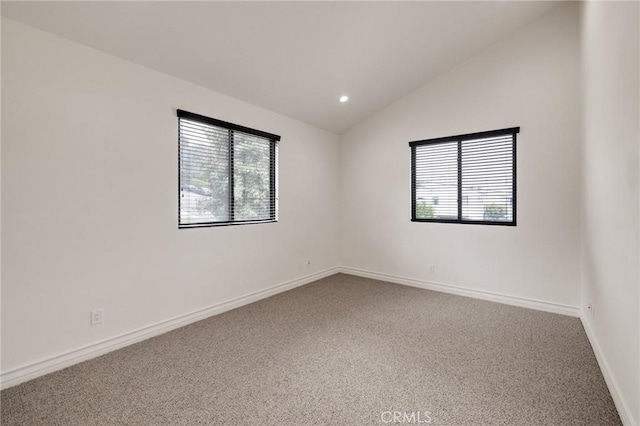 empty room featuring carpet flooring, a healthy amount of sunlight, and vaulted ceiling