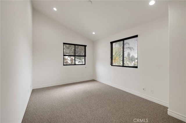 unfurnished room featuring carpet and lofted ceiling