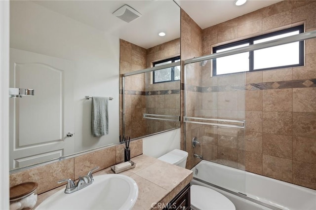 full bathroom with vanity, toilet, and bath / shower combo with glass door