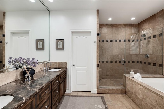 bathroom with tile patterned flooring, vanity, and shower with separate bathtub