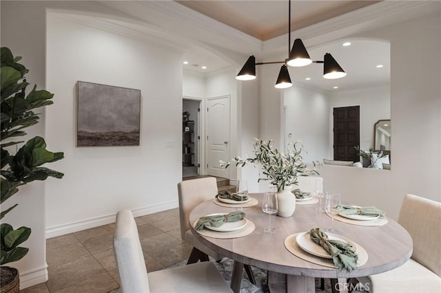 dining space featuring dark tile patterned flooring and ornamental molding