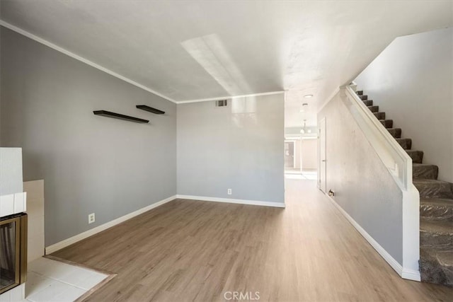 unfurnished living room with ornamental molding and light hardwood / wood-style flooring