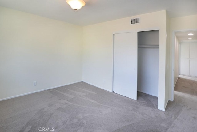 unfurnished bedroom featuring carpet flooring and a closet