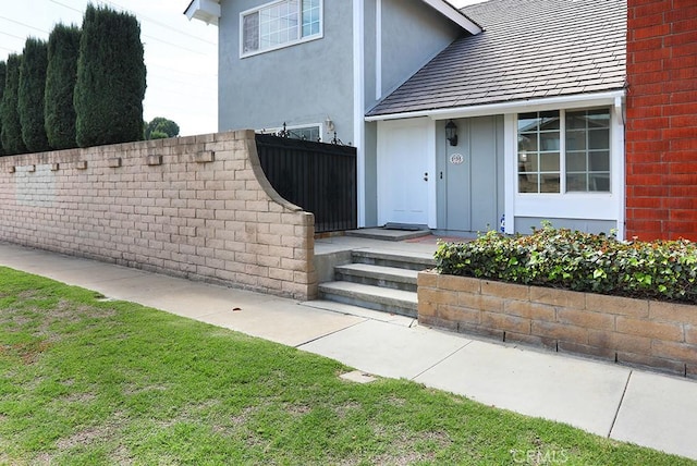 view of exterior entry with a yard