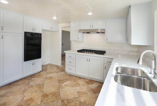 kitchen with sink, light stone countertops, double oven, white cabinetry, and gas cooktop