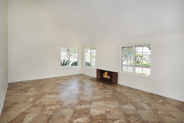 unfurnished living room featuring a fireplace and high vaulted ceiling