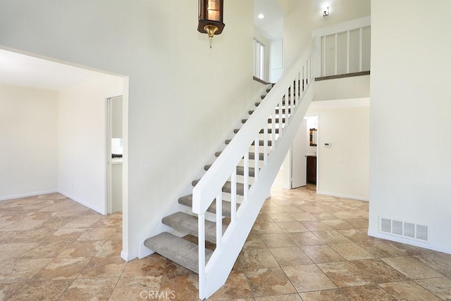 staircase with a towering ceiling