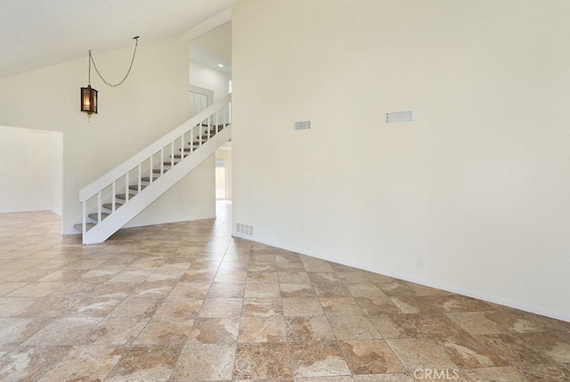 spare room featuring high vaulted ceiling and an inviting chandelier