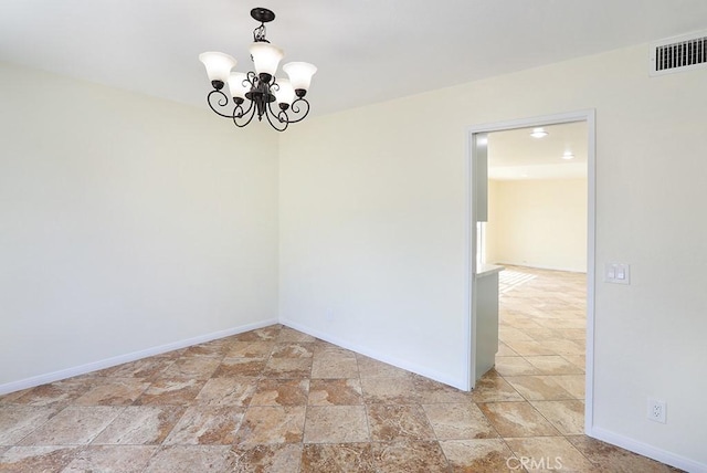 spare room featuring an inviting chandelier