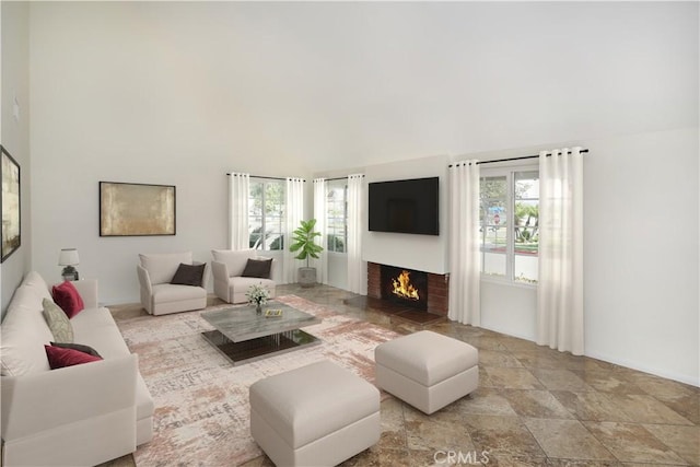 living area featuring a wealth of natural light and a lit fireplace