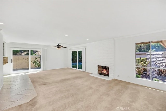 unfurnished living room with light carpet, a wealth of natural light, and a brick fireplace