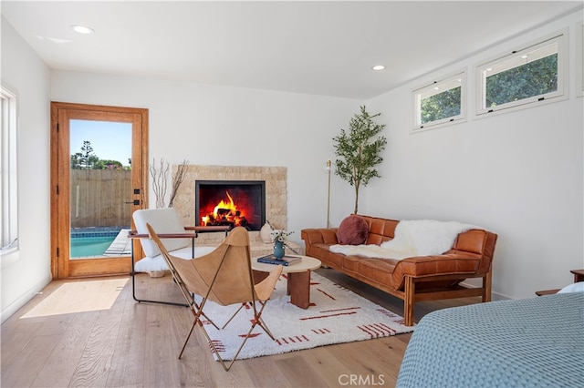 living area with light wood-type flooring and a high end fireplace