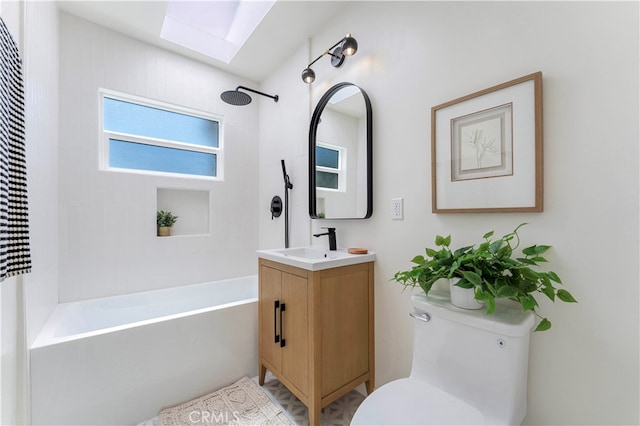 full bathroom with tiled shower / bath, vanity, and toilet