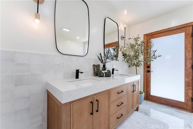 bathroom with vanity and tile walls