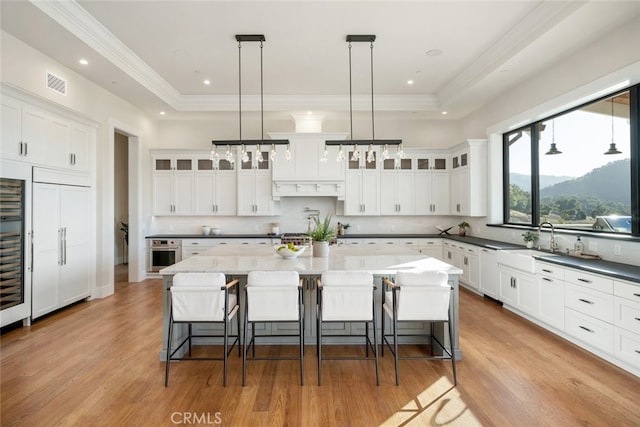 kitchen featuring a spacious island, a kitchen bar, hanging light fixtures, and oven