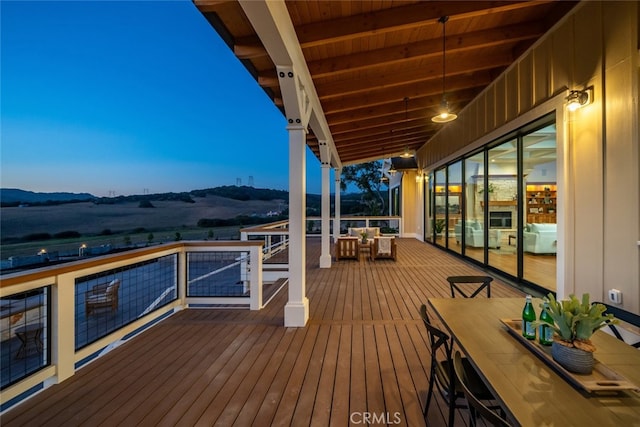 deck at dusk featuring a mountain view