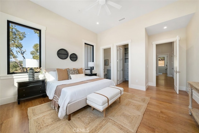 bedroom featuring light hardwood / wood-style flooring, ceiling fan, and ensuite bathroom