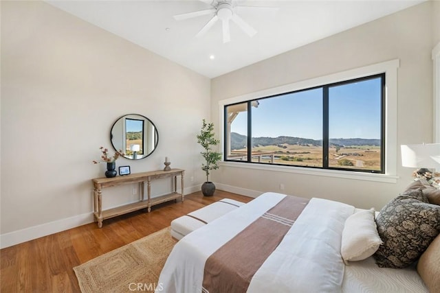 bedroom with a ceiling fan, baseboards, and wood finished floors