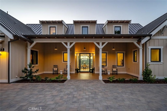 view of exterior entry featuring metal roof, board and batten siding, and a standing seam roof