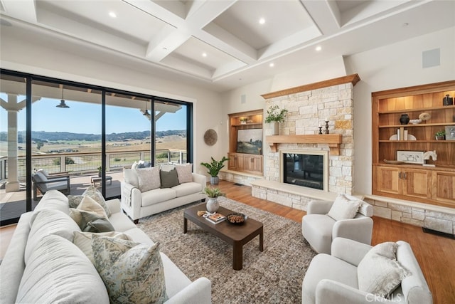 living room with light hardwood / wood-style flooring, a mountain view, coffered ceiling, and a fireplace