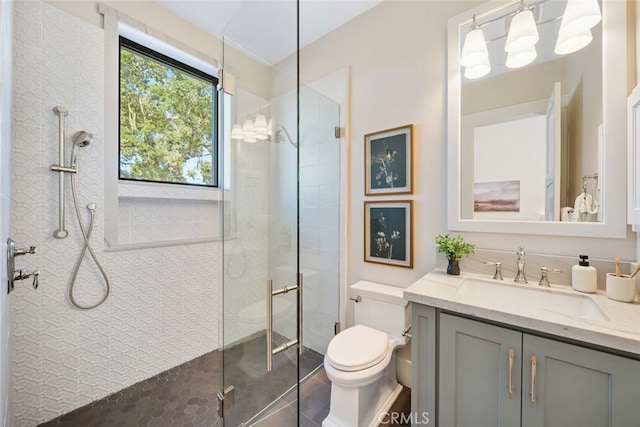 bathroom featuring vanity, an enclosed shower, and toilet