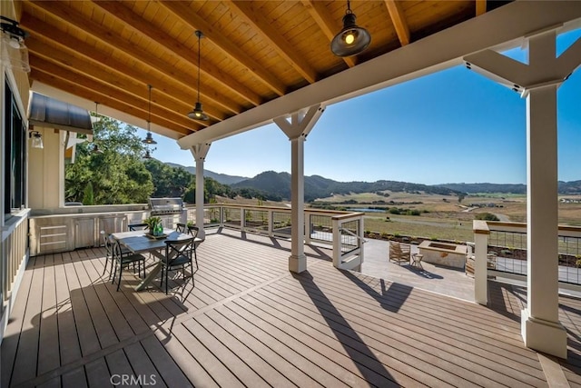 wooden deck featuring outdoor dining space and a mountain view