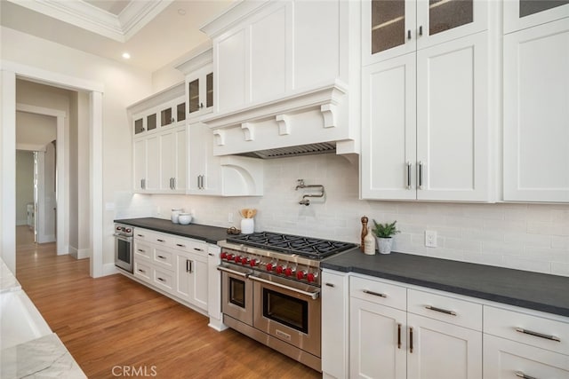 kitchen with appliances with stainless steel finishes, crown molding, backsplash, and white cabinetry