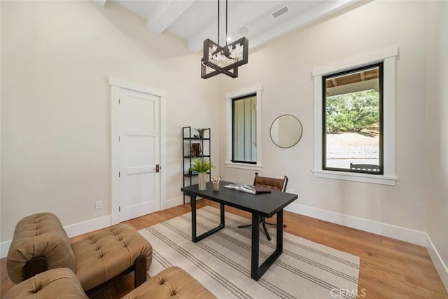 office with light wood finished floors, visible vents, baseboards, and beam ceiling