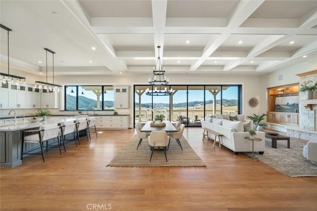 dining room featuring a chandelier, beamed ceiling, coffered ceiling, and light wood-type flooring