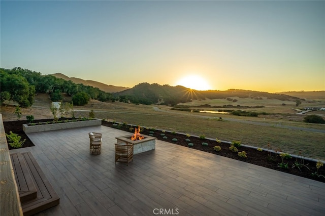 deck at dusk with a mountain view and a fire pit