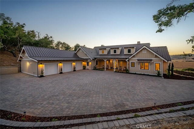 view of front of home featuring decorative driveway, metal roof, an attached garage, and a standing seam roof