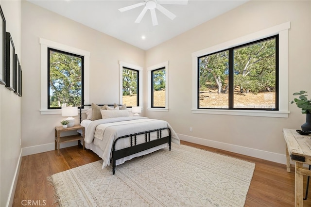 bedroom featuring wood-type flooring, multiple windows, and ceiling fan