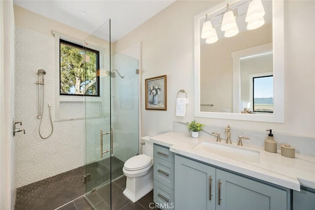 full bath featuring toilet, a stall shower, vanity, and tile patterned flooring