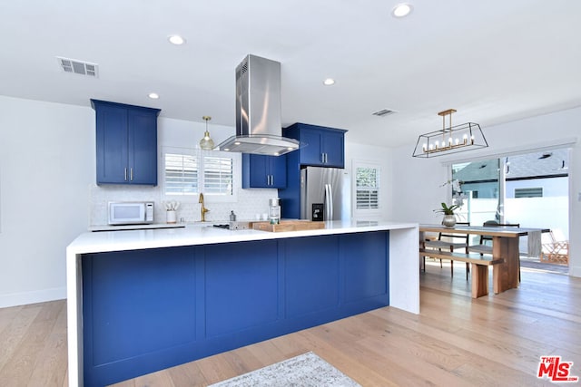 kitchen featuring blue cabinetry, stainless steel fridge with ice dispenser, island range hood, and light hardwood / wood-style floors