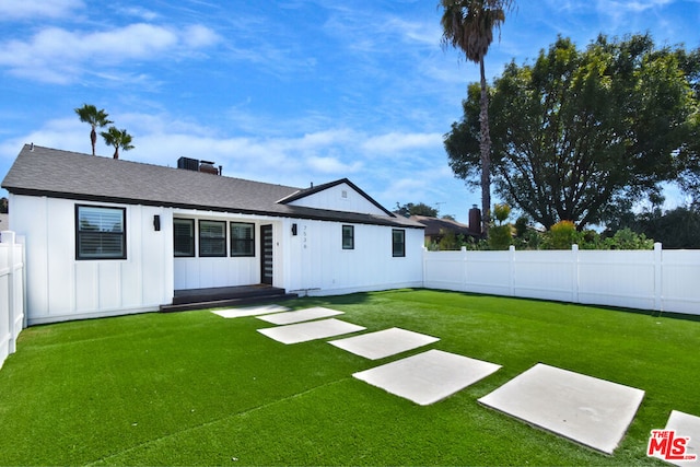 rear view of house featuring a lawn