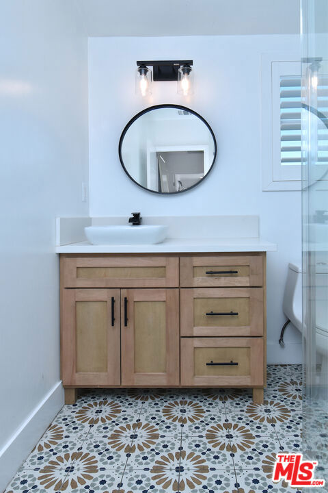 bathroom with tile patterned floors, vanity, an enclosed shower, and toilet