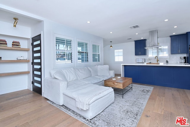 living room featuring light hardwood / wood-style flooring and sink