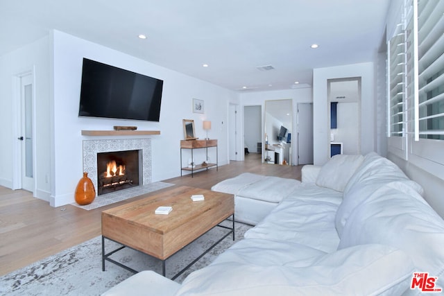 living room with light wood-type flooring and a fireplace