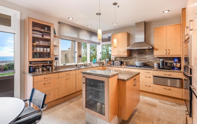 kitchen with a center island, sink, wall chimney range hood, wine cooler, and stone countertops