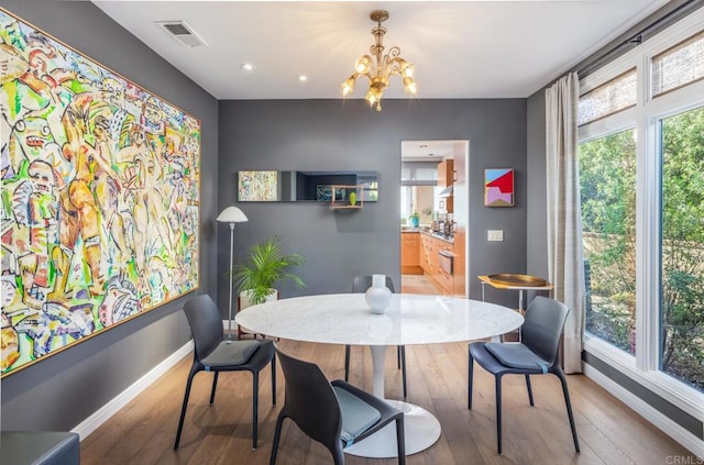 dining space with a chandelier and wood-type flooring