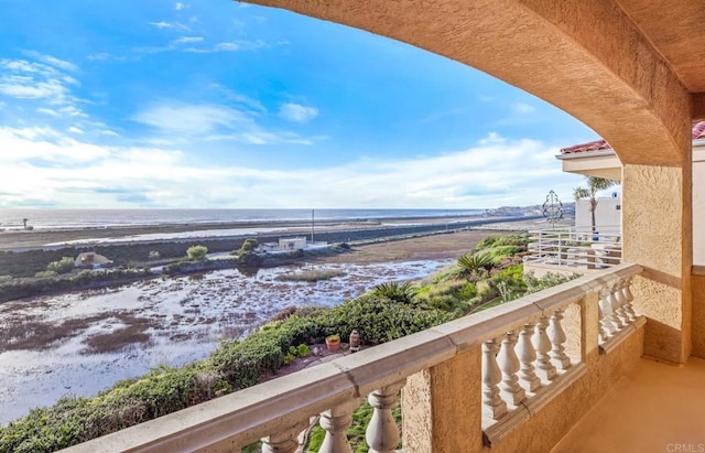 balcony featuring a water view and a beach view