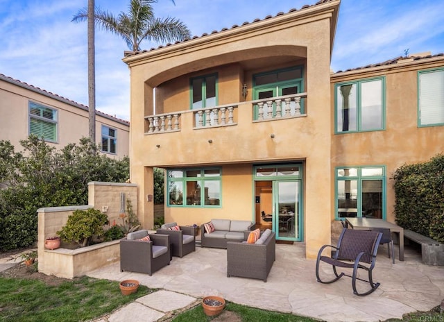 back of house with outdoor lounge area, a patio area, and a balcony