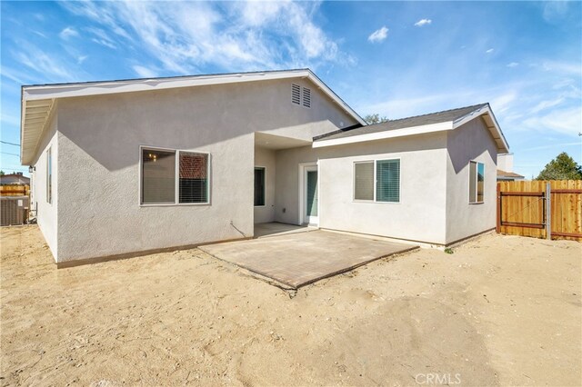 rear view of house featuring a patio and central AC