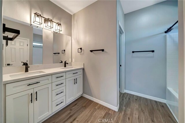 bathroom with shower / bathtub combination, vanity, and hardwood / wood-style floors