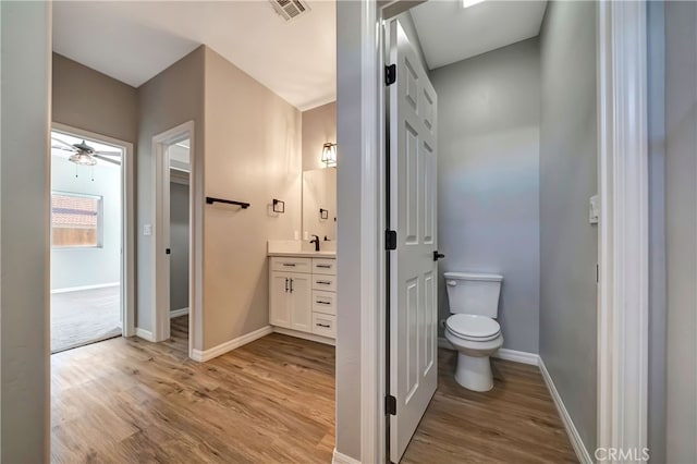 bathroom with vanity, toilet, ceiling fan, and hardwood / wood-style flooring