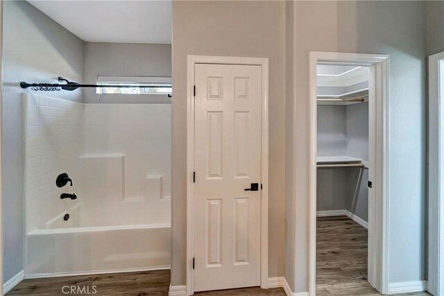 bathroom featuring wood-type flooring and shower / bathtub combination