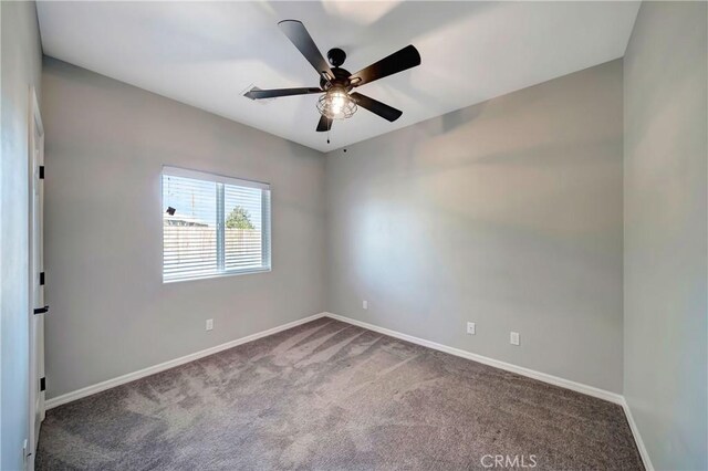 carpeted spare room with ceiling fan