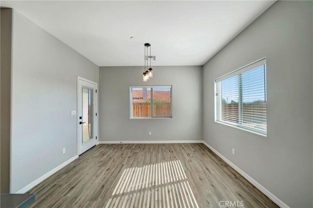 unfurnished dining area featuring light wood-type flooring and a healthy amount of sunlight